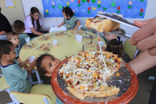 DELICIOSAS - Alunos da Creche Acalanto, no Jardim Aeroporto II, esperam ansiosos para saborear pizzas servidas por voluntários da Sapataria da Pizza, ontem, para comemorar o Dia das Crianças